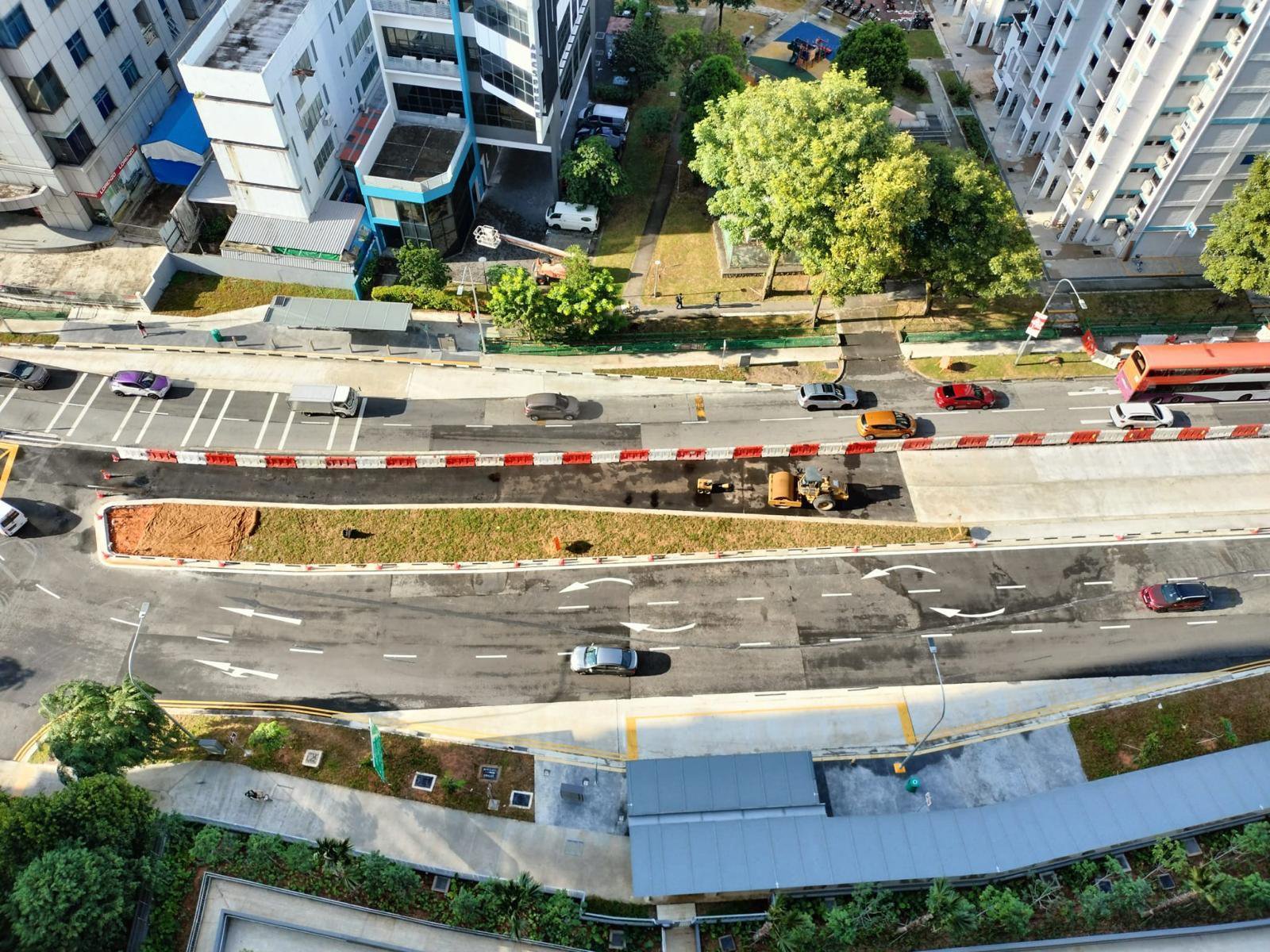 Aerial of new condominium entrance with traffic diversion barriers and roadworks