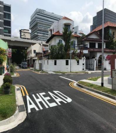Resurfaced road with new "AHEAD" lane marking and roadside walkway