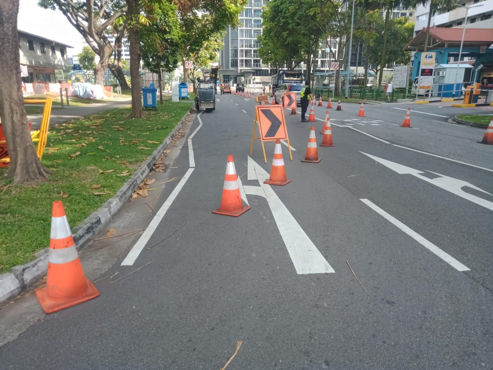 Traffic management on a Buildwick road works site — cones, arrow board and lane closure protecting workers and the travelling public